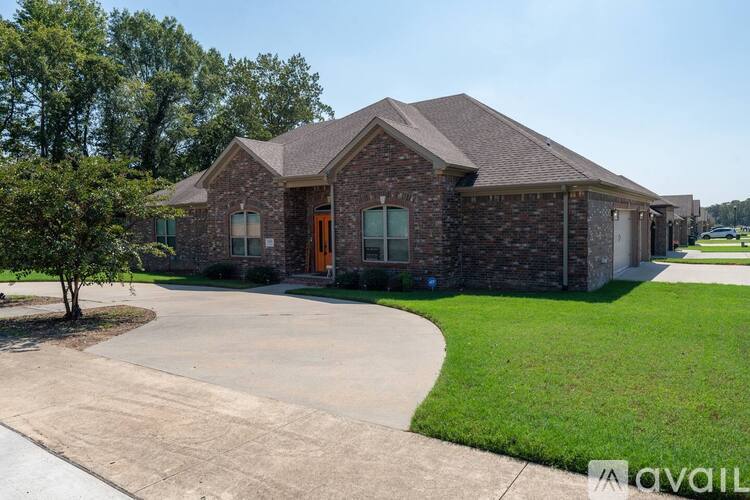 A house with a driveway and a tree in front of it.