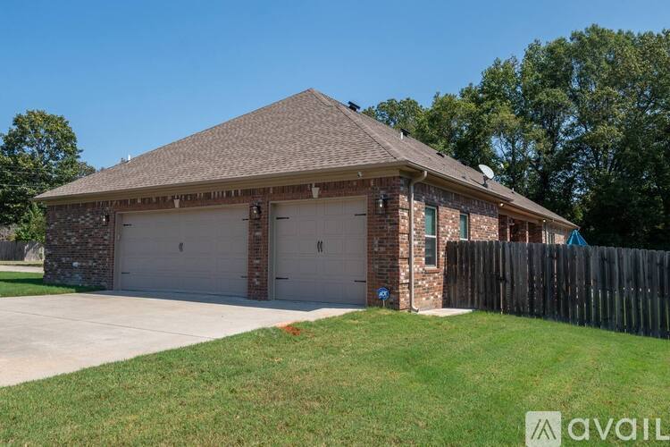A house with a garage and a fence in front of it.