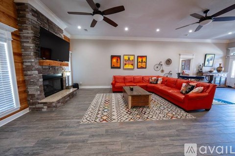 A living room with a red couch and a fireplace.