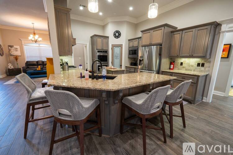 A kitchen with a granite countertop and a dining table with chairs.