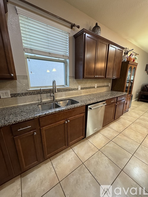 A kitchen with brown cabinets and a granite countertop.