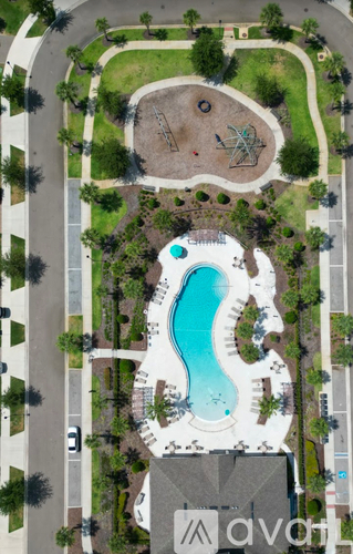 An aerial view of a park with a large swimming pool and a playground.