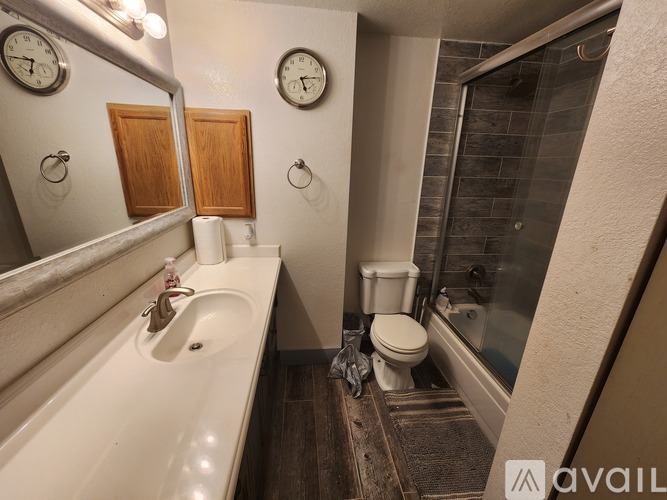 A bathroom with a white sink, toilet, and a mirror.