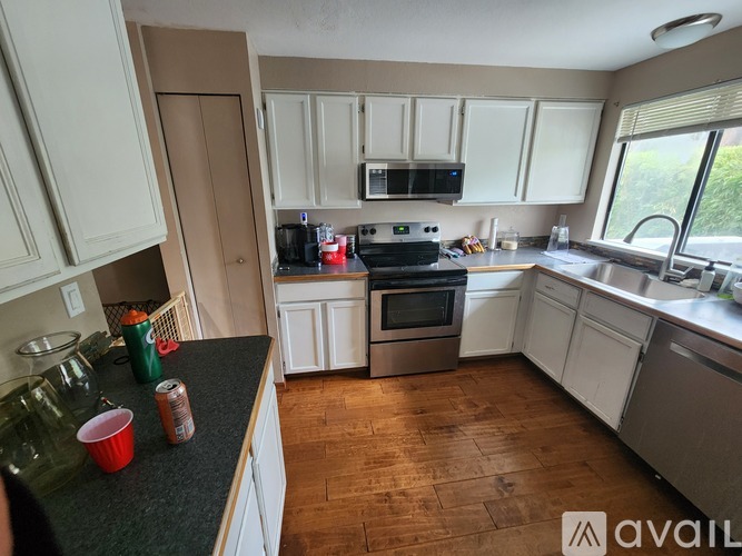 A kitchen with white cabinets and a black countertop.