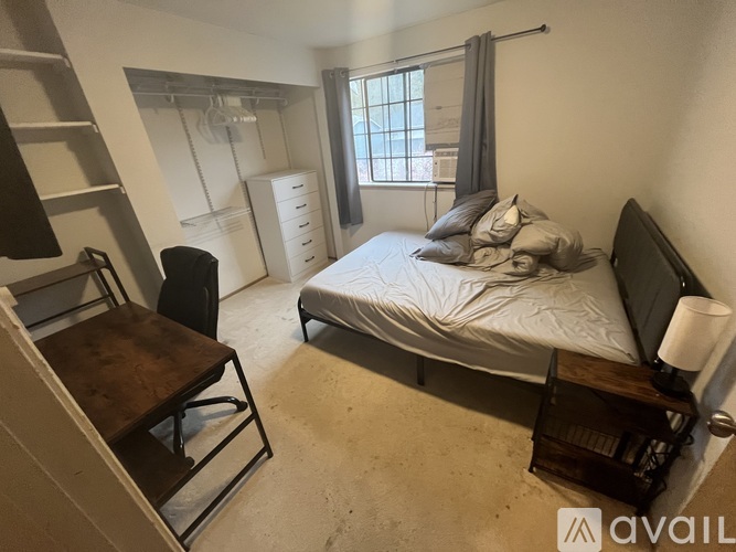 A bedroom with a bed, chair, and desk.