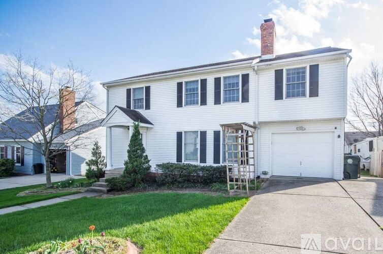 A white house with a garage and a chimney.