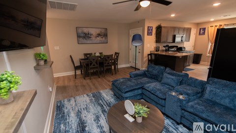 A living room with a blue couch and a dining table.
