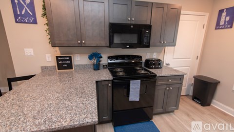 A kitchen with a granite countertop and a black stove top oven.