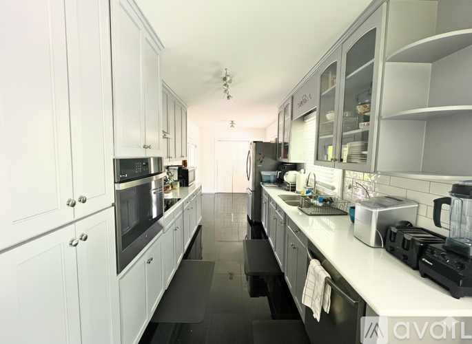 A kitchen with white cabinets and black appliances.