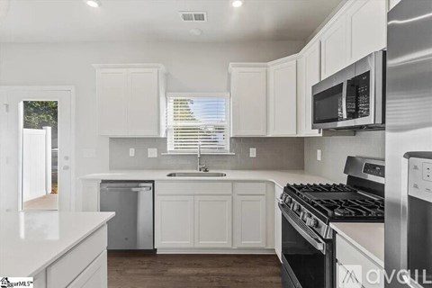 A kitchen with white cabinets and stainless steel appliances.