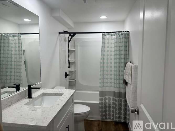 A bathroom with a sink, toilet, and shower.