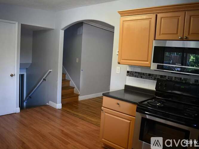A kitchen with wooden cabinets and a black stove top oven.
