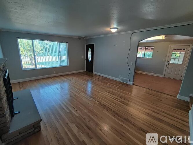 A room with wooden flooring and a door with a round window.