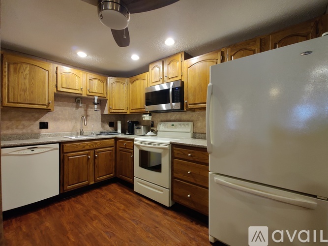 A kitchen with wooden cabinets and a white refrigerator.