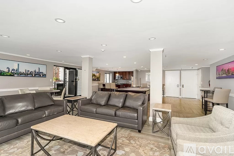 A living room with a black leather couch and a wooden coffee table.