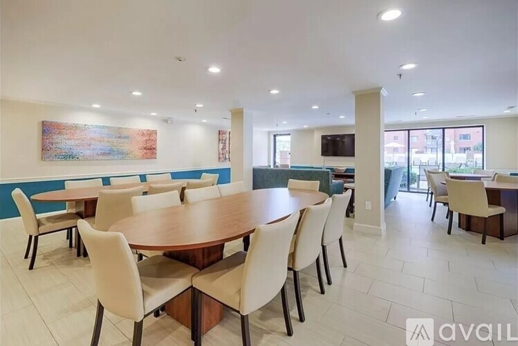 A dining room with a large table and chairs.