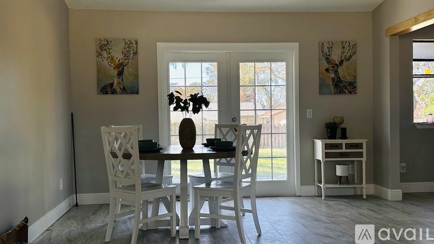 A dining room with a white table and chairs.