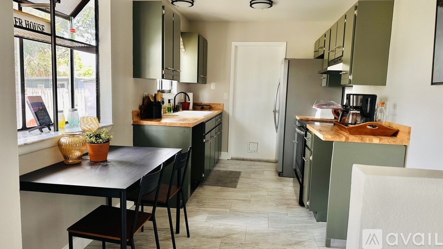 A kitchen with a table and chairs in front of a window.