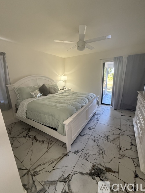 A bedroom with a marble floor and a large bed.