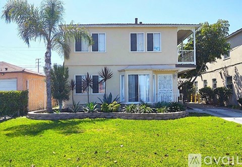 A house with a green lawn in front of it.