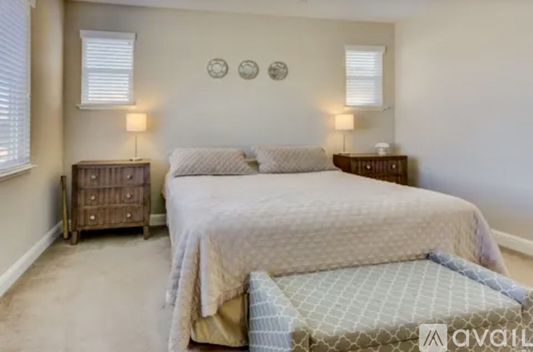 A bedroom with a large bed and two nightstands.