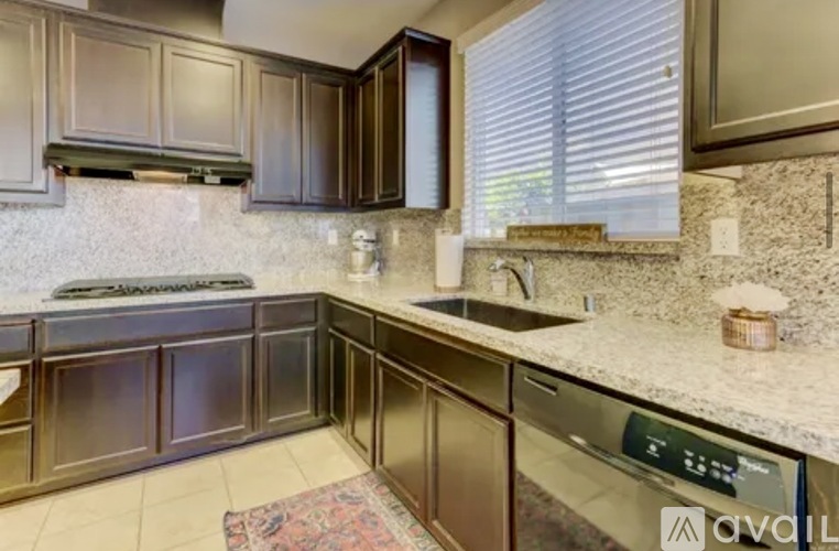 A kitchen with brown cabinets and a granite countertop.