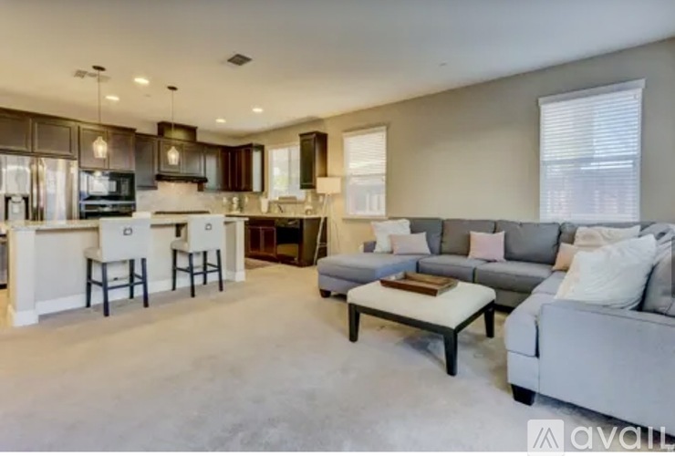 A spacious living room with a grey sofa and a coffee table.