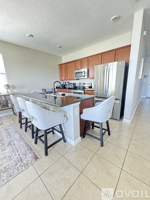 A kitchen with white chairs and a white counter.