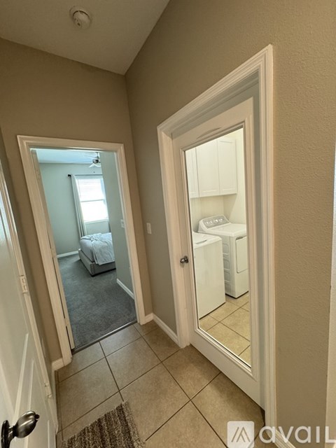 A bedroom with a bed and a wardrobe is visible through a glass door.