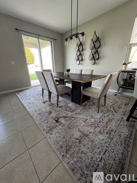 A dining room with a table and chairs.