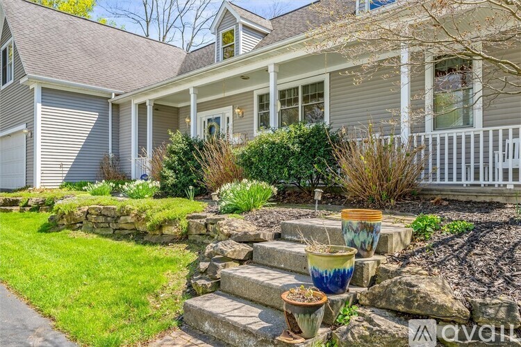 A house with a front yard and steps leading to the front door.
