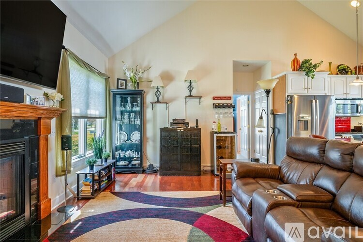 A living room with a brown leather couch and a television.