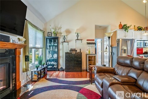 A living room with a brown leather couch and a television.