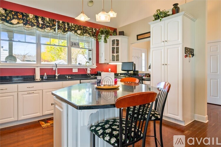 A kitchen with a black and white theme and a wooden chair.