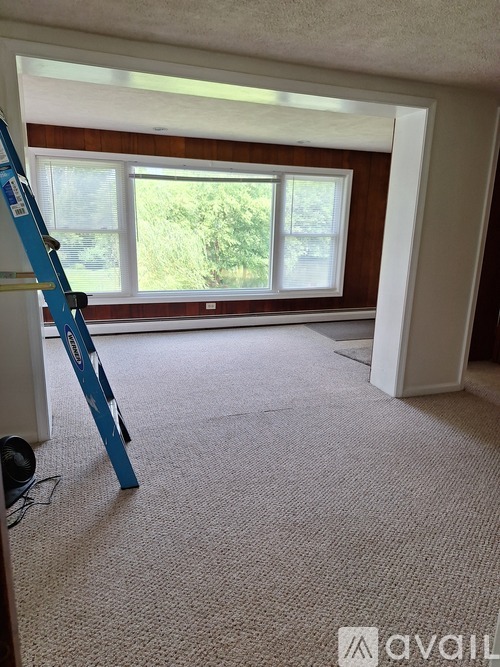 A room with a ladder and a window.