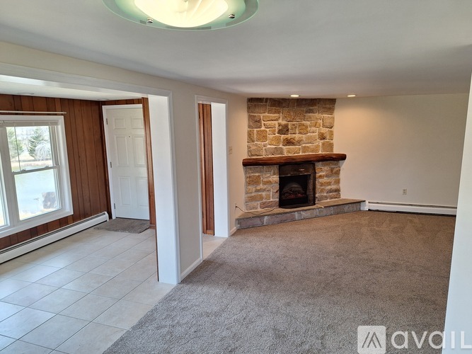 A living room with a fireplace and a carpeted floor.