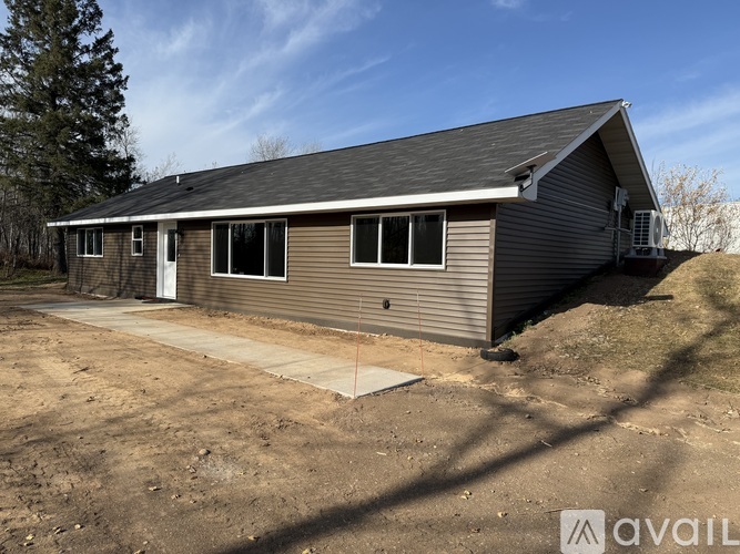 A house with a grey roof and a white door is available for purchase.