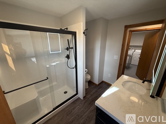 A bathroom with a glass shower door and a white sink.