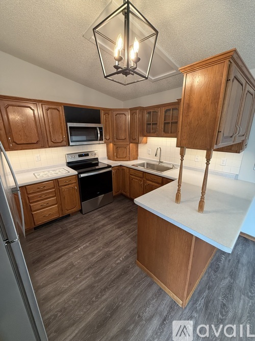 A kitchen with wooden cabinets and a white countertop.