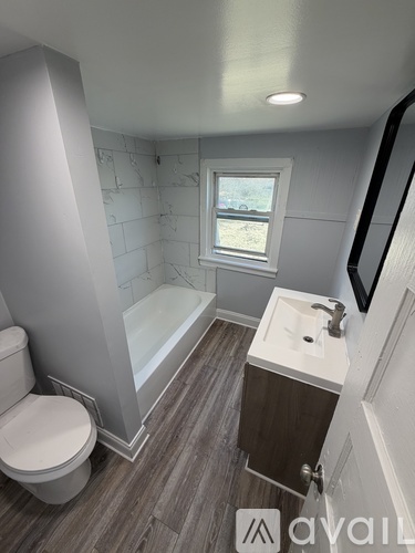 A bathroom with a toilet, sink, and bathtub.