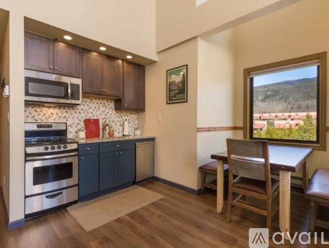 A kitchen with dark brown cabinets and a white stove top oven.