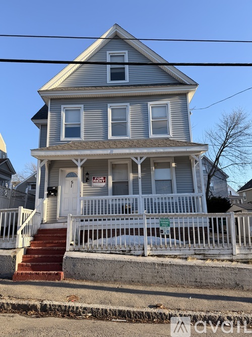 A two-story house with a grey facade and a white porch.