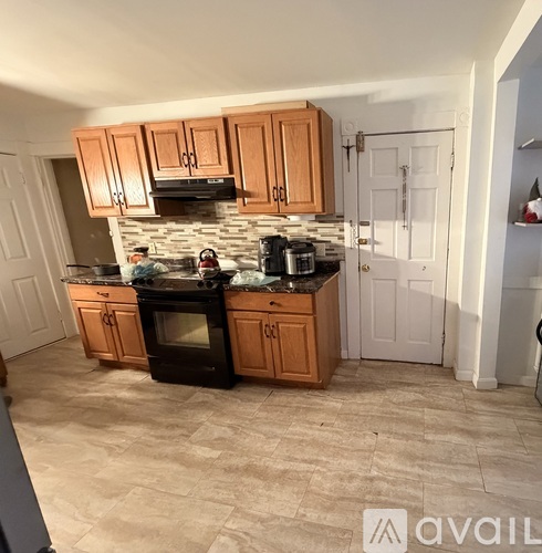 A kitchen with wooden cabinets and a black stove top oven.