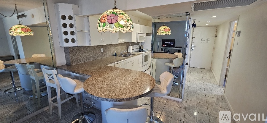 A kitchen with a table and chairs and a stained glass lamp hanging from the ceiling.