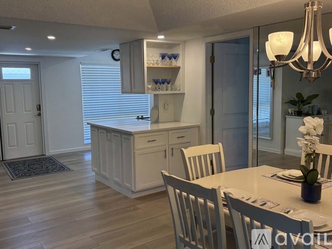 A dining room with a white table and chairs.