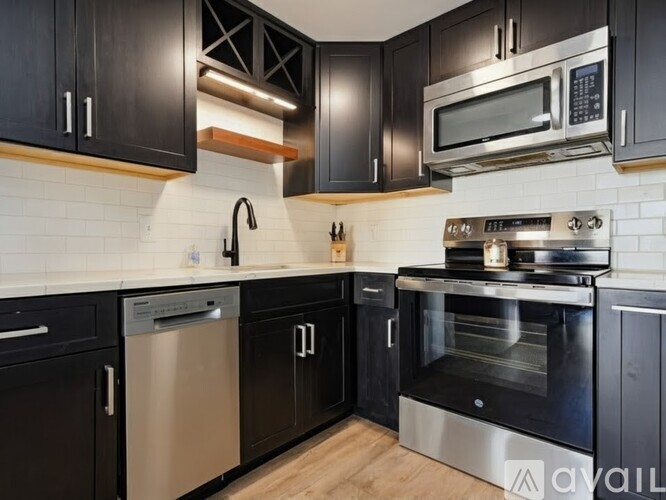 A kitchen with black cabinets and stainless steel appliances.