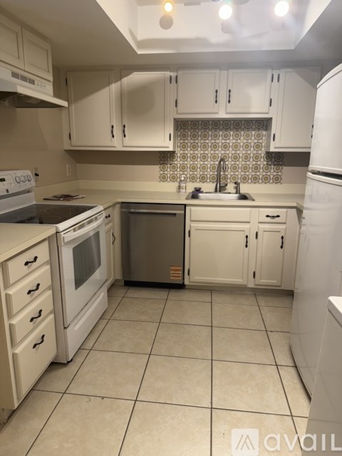 A kitchen with white appliances and cabinets.