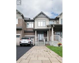 A white car is parked in front of a house.
