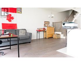 A living room with a grey couch, a coffee table, and a printer on the desk.