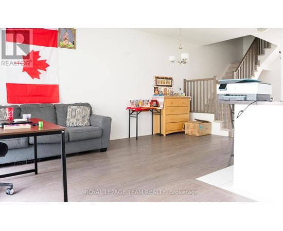 A living room with a grey couch, a coffee table, and a printer on the desk.